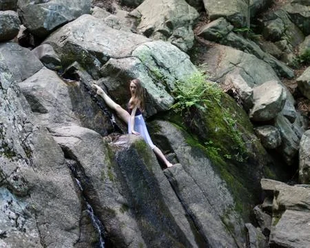 Dancer posing on a waterfall Stock Photos