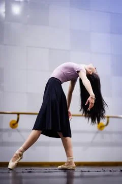 Dancer practices in a studio with natural light during the afternoon while Stock Photos