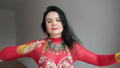 A dancer in a red suit is dancing an oriental dance on a white background. A Stock Footage 267707420