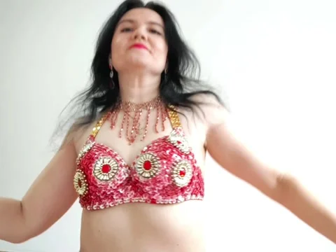A dancer in a red suit is dancing an oriental dance on a white background. A Stock Footage 269287534