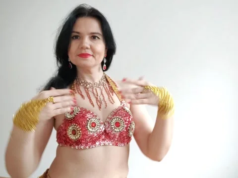 A dancer in a red suit is dancing an oriental dance on a white background. A Stock-Footage 275225294