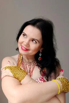 A dancer in a red suit is dancing an oriental dance on a white background. A Stock Photos
