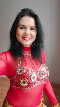A dancer in a red suit is dancing an oriental dance on a white background. A Stock Photos