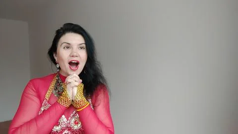 A dancer in a red suit is dancing an oriental dance on a white background Stock Photos