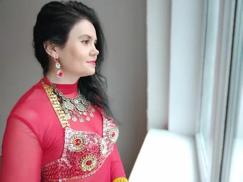 A dancer in a red suit is dancing an oriental dance on a white background. Free Stock Photos