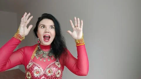 A dancer in a red suit is dancing an oriental dance on a white background Stock Photos