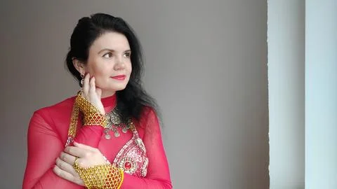 A dancer in a red suit is dancing an oriental dance on a white background. Free Stock Photos