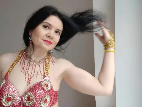 A dancer in a red suit is dancing an oriental dance on a white background. Free Foto stock
