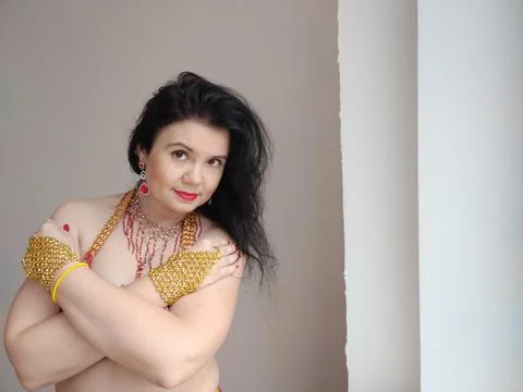 A dancer in a red suit is dancing an oriental dance on a white background. Free Foto stock