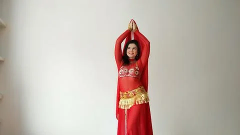 A dancer in a red suit is dancing with a red shawl an oriental dance on a white Stock Photos