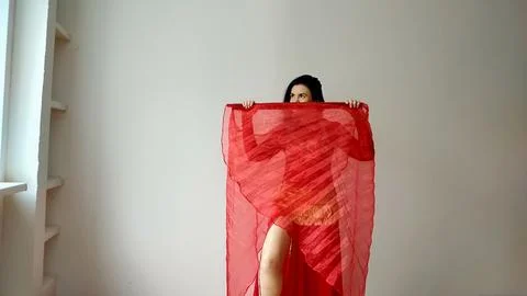 A dancer in a red suit is dancing with a red wings an oriental dance on a white Stock Photos