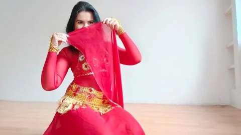 A dancer in a red suit is dancing with a red shawl an oriental dance on a white Stock Photos