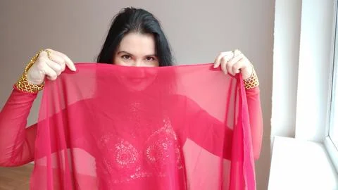A dancer in a red suit is dancing with a red shawl an oriental dance on a white Stock Photos