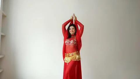 A dancer in a red suit is dancing with a red shawl an oriental dance on a white Stock Photos