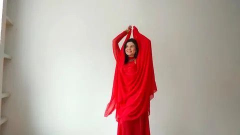 A dancer in a red suit is dancing with a red shawl an oriental dance on a white Stock Photos