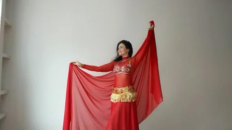 A dancer in a red suit is dancing with a red shawl an oriental dance on a white Stock Photos