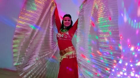 A dancer in a red suit is dancing with a wings an oriental dance on the Stock Photos