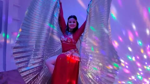 A dancer in a red suit is dancing with a wings an oriental dance on the Foto stock
