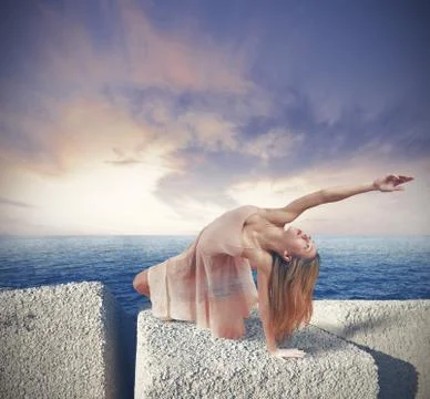 Dancer on the rock dsuring sunset Stock Photos