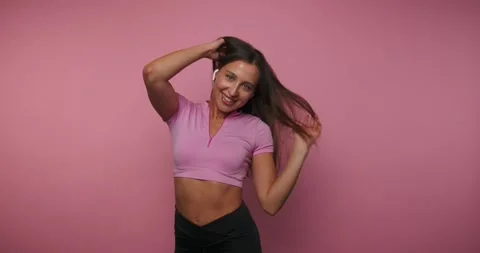 Dancer shows moves and smiles in studio with pink background while playing .. Vídeos de archivo 331990268