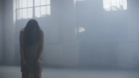 Dancer slowly begins to move rocking back and forth in warehouse 스톡 동영상 104477559