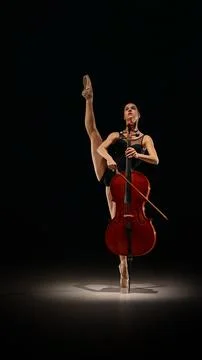 Dancer standing en pointe while playing cello in strong vertical classical pose. Stock Photos