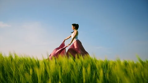 Dancer stands on one leg with chiffon in field slow motion Stock Footage 113508590