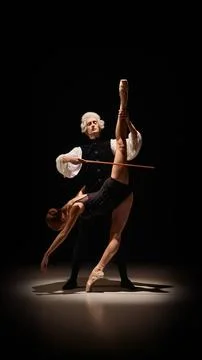 Dancer stretched like tuned instrument under classical mentor control on stage Stock Photos