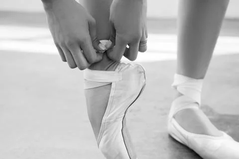 Dancer tighten the pointes in a dancing studio. Black and white photo Stock Photos