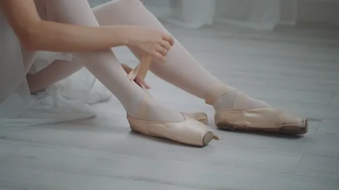 Dancer wears ballet slippers. Close-up of ballerina's legs with pointe shoes Stock Footage 121757229