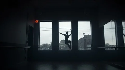 Dancer on window sill dancing in large dark moody dance studio Vídeo Stock 104275198