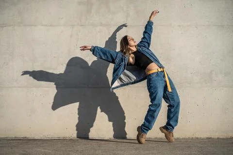 Dancer woman making a pose like an eagle. Casual dress and shadow reflected o Stock Photos