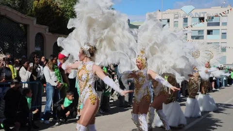 Dancers in feather costumes perform at vibrant parade Stock Footage 327329261