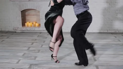Dancers perform classical tango near decorative fireplace Stock Footage 138727902