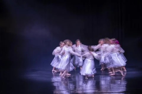 Dancers performing an expressive circular movement on stage Stock Photos