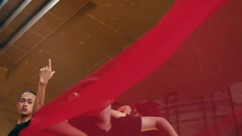 Dancers Performing Under Flowing Red Fabric, Low Angle Stock Footage 249365818