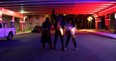 Dancers setting off smoke bombs under an overpass at night Stock Footage 100182843