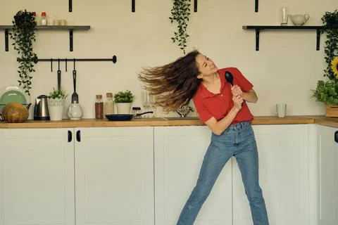 Dancing and singing while cooking uses the pilgrim as a microphone, a cheerful Stock Photos