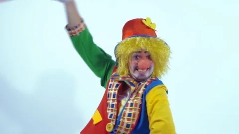 Dancing and smiling circus clown turning around and waving an orange cloth Stock-Footage 70515065