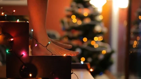 Dancing barefoot on glowing staircase on the background of the Christmas tree. Stock Footage 70739049