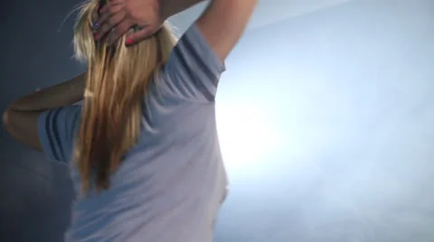 A dancing from behind on lights with blonde loose hair Video stock 22824625