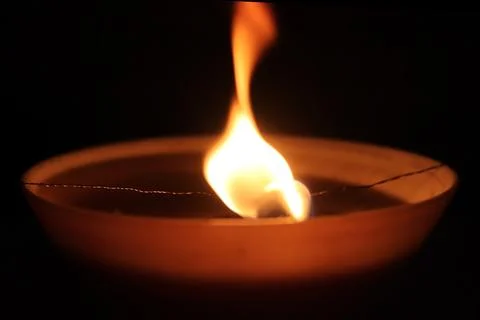 Dancing candle fire twinkle. Warm orange background. Stock Photos