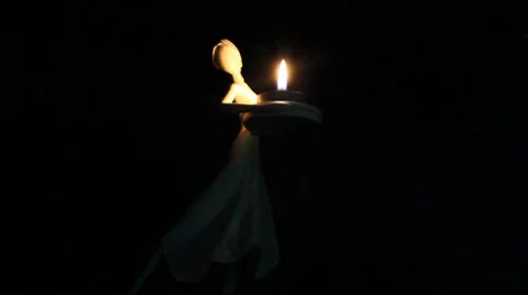Dancing Candleholder in front of dark background Stock Footage 7522648