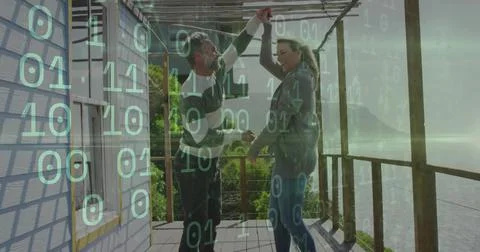 Dancing couple holding hands under pergola beams on wooden deck, green binary 库存照片