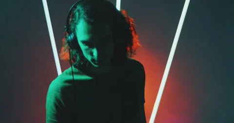 Dancing deejay cool guy wearing headphones during performance in nightclub in Stock Footage 157292039