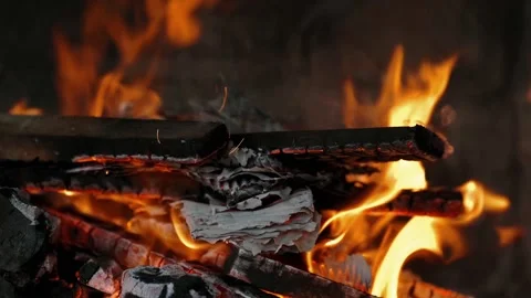 Dancing flames and vibrant sparks create an enchanting glow that lights up Stock Footage 296515664