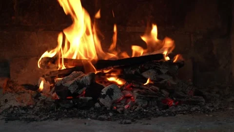 Dancing flames and vibrant sparks create an enchanting glow that lights up Stock Footage 296515670