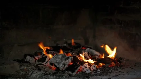 Dancing flames and vibrant sparks create an enchanting glow that lights up Stock Footage 296515708