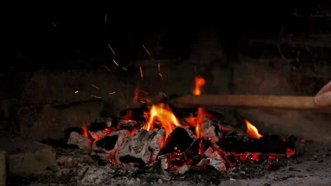 Dancing flames and vibrant sparks create an enchanting glow that lights up Stock Footage 296515729