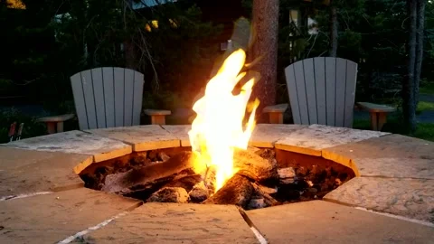 Dancing flames in stone firepit outdoors at night time Video stock 144298297
